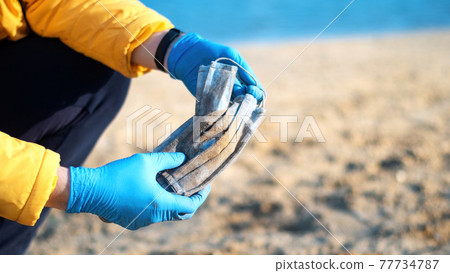 Man picking up dirty medical masks from the ground Man picking up dirty medical masks from the ground 77734787