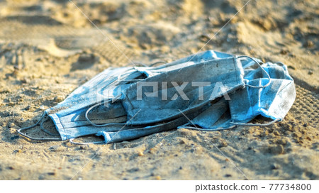 A bunch of medical masks on the beach of a lake A bunch of medical masks on the beach of a lake 77734800