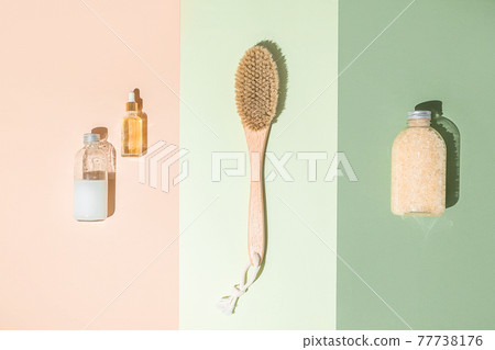 Body treatment and spa composition. Flat lay with natural beauty products. Bath salt, serum bottle. Brush for dry anti-cellulite massage. Dropper glass Oily cosmetic pipette 77738176
