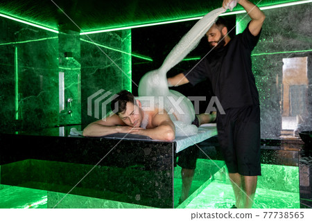 Man on the procedure of the foam massage in the hammam Man on the procedure of the foam massage in the hammam 77738565