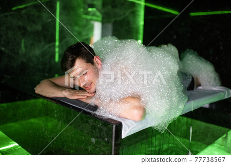 Man on the procedure of the foam massage in the hammam 77738567