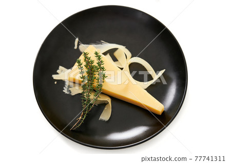 Juicy appetizing piece of cheese with sprig of rosemary. Juicy appetizing piece of cheese with sprig of rosemary. 77741311