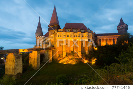 Illuminated Corvin Castle in night, Romania 77741446
