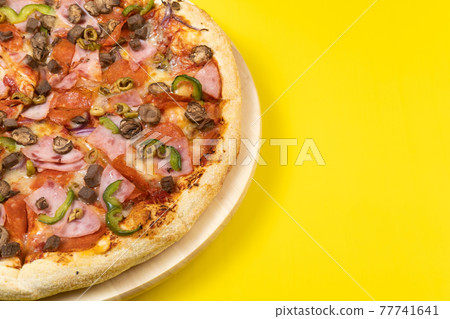 Delicious large pizza with veal and mushrooms on a yellow background 77741641