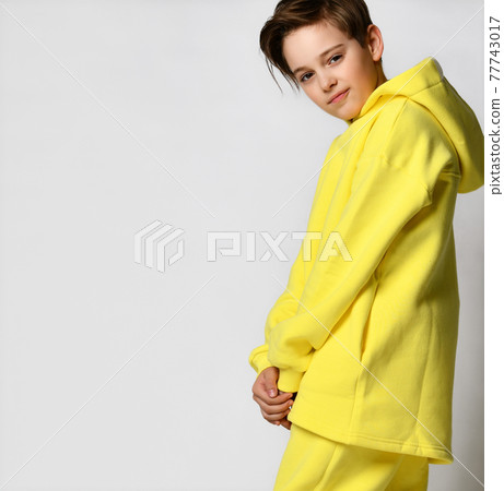 Studio portrait of a little boy in a warm yellow 77743017