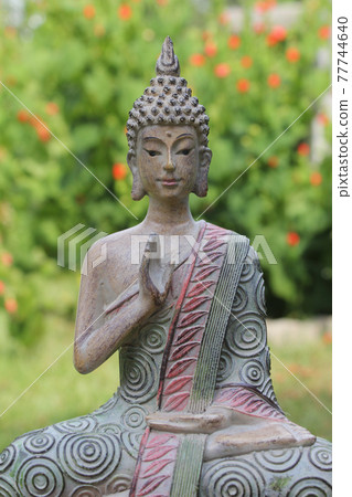 Buddha Statue in Outdoor Garden With Blurred Background 77744640