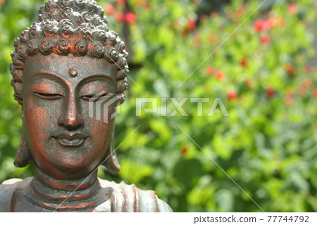 Buddha Statue in Outdoor Garden With Blurred Background 77744792