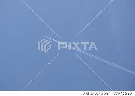 A pure white contrail that rushes straight through the blue sky 3 from the bottom right to the top A pure white contrail that rushes straight through the blue sky 3 from the bottom right to the top 77745580