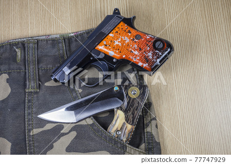 Gun on camouflage background. Gun on camouflage background. 77747929