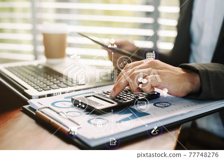 Investors are calculating on calculator investment costs and holding tablet in hand at home office. Investors are calculating on calculator investment costs and holding tablet in hand at home office. 77748276