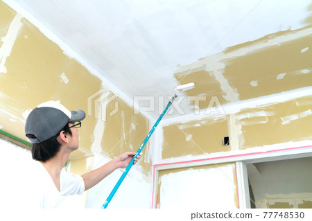 A painter who works at a construction site A painter who works at a construction site 77748530