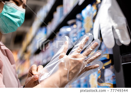 Female wear plastic gloves before buying food in supermarket during the Coronavirus outbreak,prevent infection of the pandemic COVID-19,free plastic gloves service before shopping,safety,health care Female wear plastic gloves before buying food in supermarket during the Coronavirus outbreak,prevent infection of the pandemic COVID-19,free plastic gloves service before shopping,safety,health care 77749344