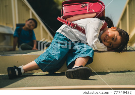 一年級學生背著沉重的書包 77749482