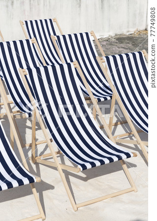 Close up group of Empty Blue stripe Beach chairs Close up group of Empty Blue stripe Beach chairs 77749808