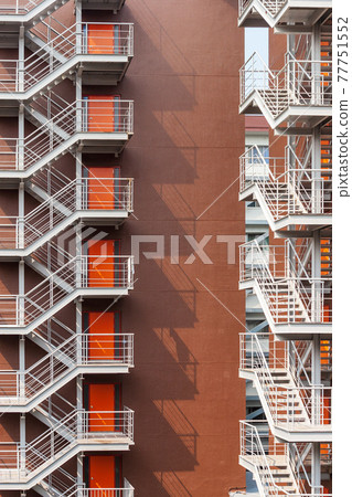 高樓後面的鐵製應急樓梯的影子和掉在牆上的扶手 77751552