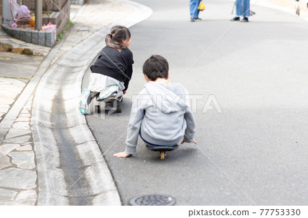 Kids playing skateboarding with friends Kids playing skateboarding with friends 77753330