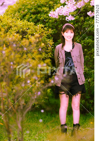 A portrait of a woman with petals dancing under a cherry tree A portrait of a woman with petals dancing under a cherry tree 77753628