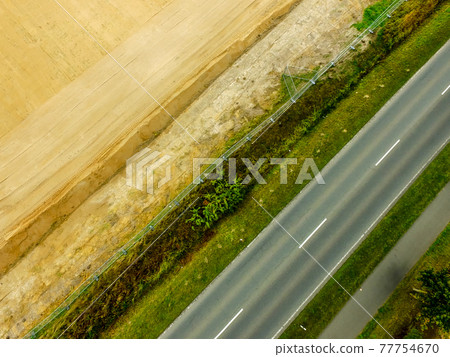 Graphic and abstract aerial view of the vertical photograph of a road with markings between fields. Graphic and abstract aerial view of the vertical photograph of a road with markings between fields. 77754670