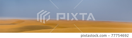 Intentionally blurred panorama of a desert landscape with sand dunes and blue sky Intentionally blurred panorama of a desert landscape with sand dunes and blue sky 77754692