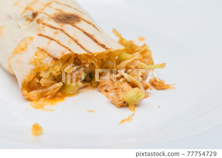 The cut shawarma in a lavash. Juicy stuffing of shawarma. Street food on a white background The cut shawarma in a lavash. Juicy stuffing of shawarma. Street food on a white background 77754729