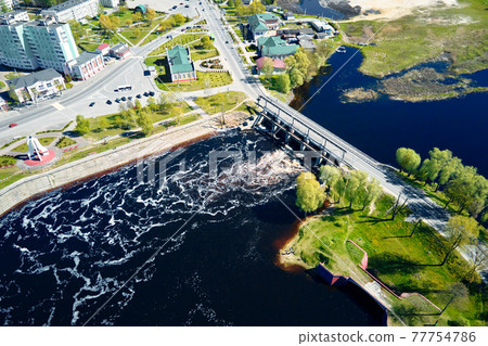 Small town landscape with bridge over river, aerial view. 77754786