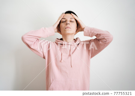 Beautiful young millennial woman doing face yoga at home. Fascial exercises for building youthful Beautiful young millennial woman doing face yoga at home. Fascial exercises for building youthful 77755321