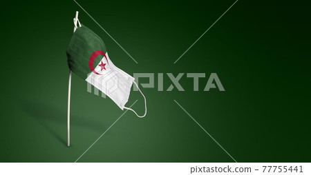 Algeria mask on dark blue background. Waving flag of Algeria painted on medical mask on pole. Concept of The banner of the fight against the epidemic coronavirus COVID-19. Copy space 77755441