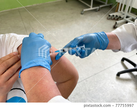 Hand of medical staff injecting coronavirus covid-19 vaccine. Hand of medical staff injecting coronavirus covid-19 vaccine. 77755997