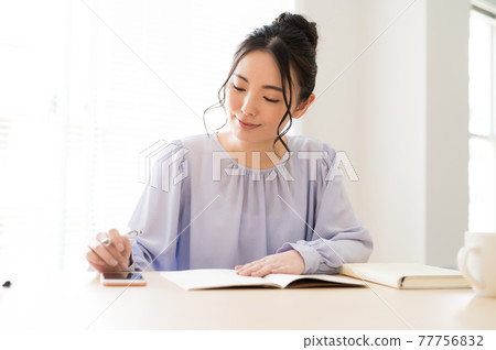 A woman studying for a seminar using a smartphone A woman studying for a seminar using a smartphone 77756832