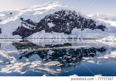Snowy mountain peak and the glacier reflected in the Antarctic waters of Neco bay, Antarctica 77757367