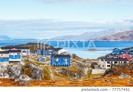 Inuit houses and cottages in residential district of Nuuk city with fjord and mountains in the background, Greenland 77757492
