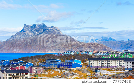 Inuit houses and cottages scattered across tundra landscape in residential suburb of Nuuk city with fjord and mountains in the background, Greenland Inuit houses and cottages scattered across tundra landscape in residential suburb of Nuuk city with fjord and mountains in the background, Greenland 77757498