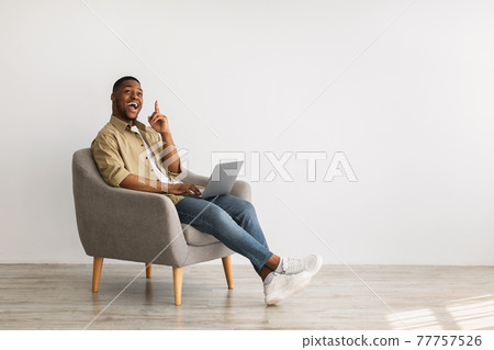 Excited African Man With Laptop Pointing Finger Up, Gray Background Excited African Man With Laptop Pointing Finger Up, Gray Background 77757526