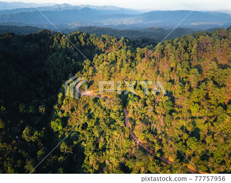 Road through a valley from above 77757956