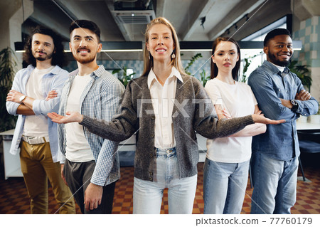 Group portrait of five diverse young colleagues standing in a row in office 77760179