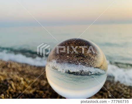 close up crystal glass ball at the beach.  77760735