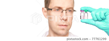 Male person in green glove hold vaccine bottles. Injection drug pharmacy concept 77761299