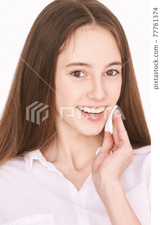 Female teenager person. Cleansing dirty skin. Remove mascara. Cotton pad face 77761374