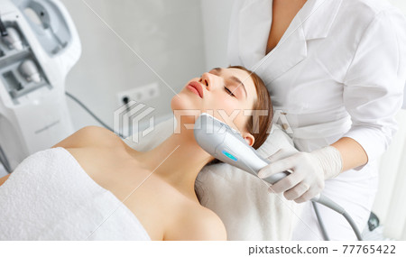 Woman getting facial lifting therapy in beauty salon 77765422