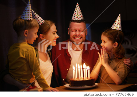Young man father going to blow candles on chocolate cake while celebrating his Birthday with family Young man father going to blow candles on chocolate cake while celebrating his Birthday with family 77765469