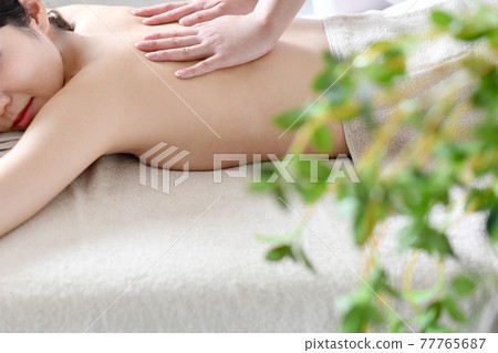 Young woman undergoing esthetic treatment in a massage bed 77765687