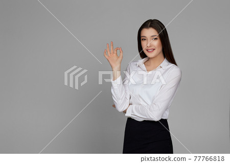 beautiful business woman in white shirt showing Ok gesture beautiful business woman in white shirt showing Ok gesture 77766818