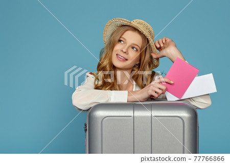 smiling blonde woman with gray suitcase, passport 77766866