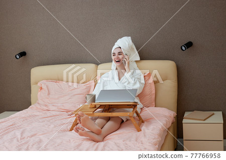 young beautiful caucasian woman in white bathrobes and towels on heads 77766958