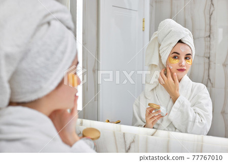 beautiful woman with eye patches in white bathrobes in bathroom 77767010