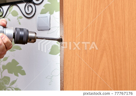 Locksmith use a flat bit to wood when drilling a hole for latch. 77767176