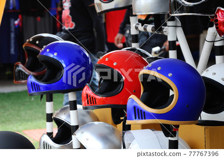 KUALA LUMPUR, MALAYSIA -FEBRUARY 25, 2017: Motorcycle helmets in various color with retro design. This design was popular during 50's and 60's. KUALA LUMPUR, MALAYSIA -FEBRUARY 25, 2017: Motorcycle helmets in various color with retro design. This design was popular during 50's and 60's. 77767396