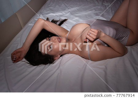 Attractive woman in underwear lying on bed Attractive woman in underwear lying on bed 77767914