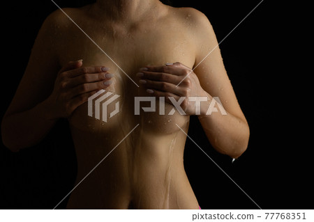 Nude woman with wet body in studio 77768351