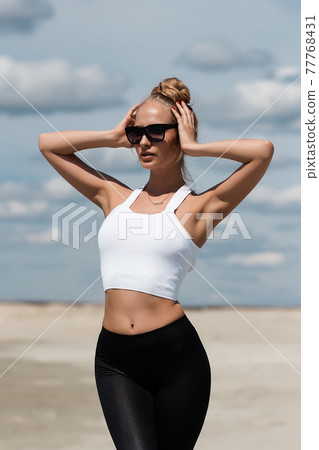 Slim woman stretching raising hands on beach 77768431